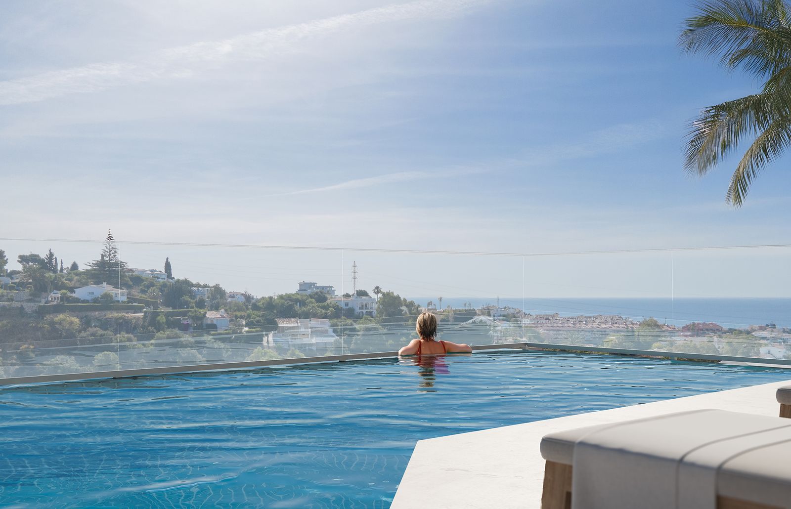 Vrouw ontspant in zwembad met uitzicht bij Belvedere Collection.